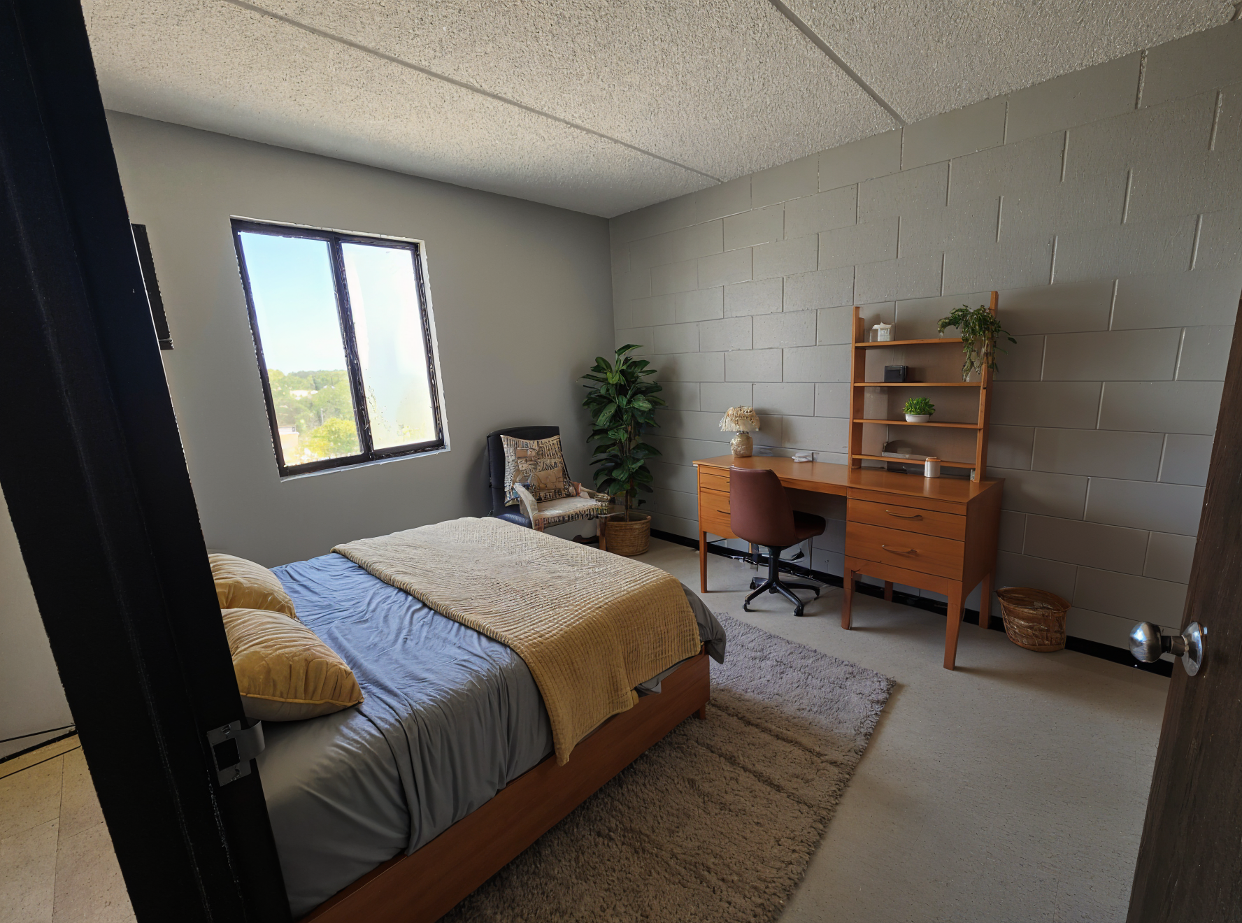 MetroView apartment bedroom with a bed, desk, and window