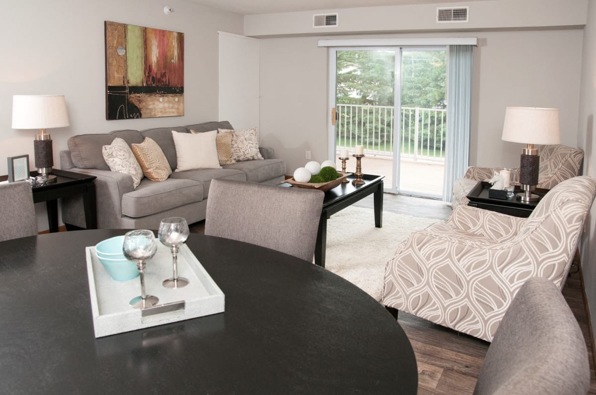 Furnished living room with wood-look flooring and a balcony door