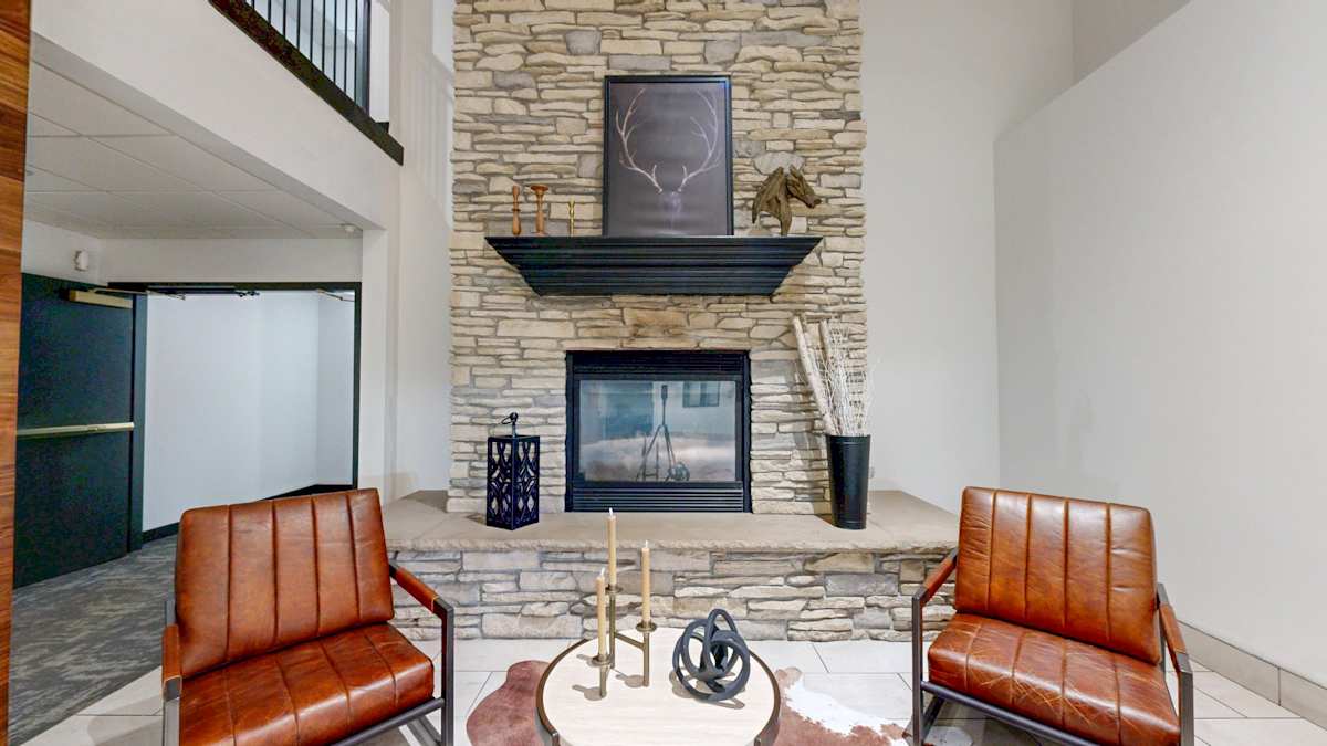 Lobby seating beside a tall stone fireplace