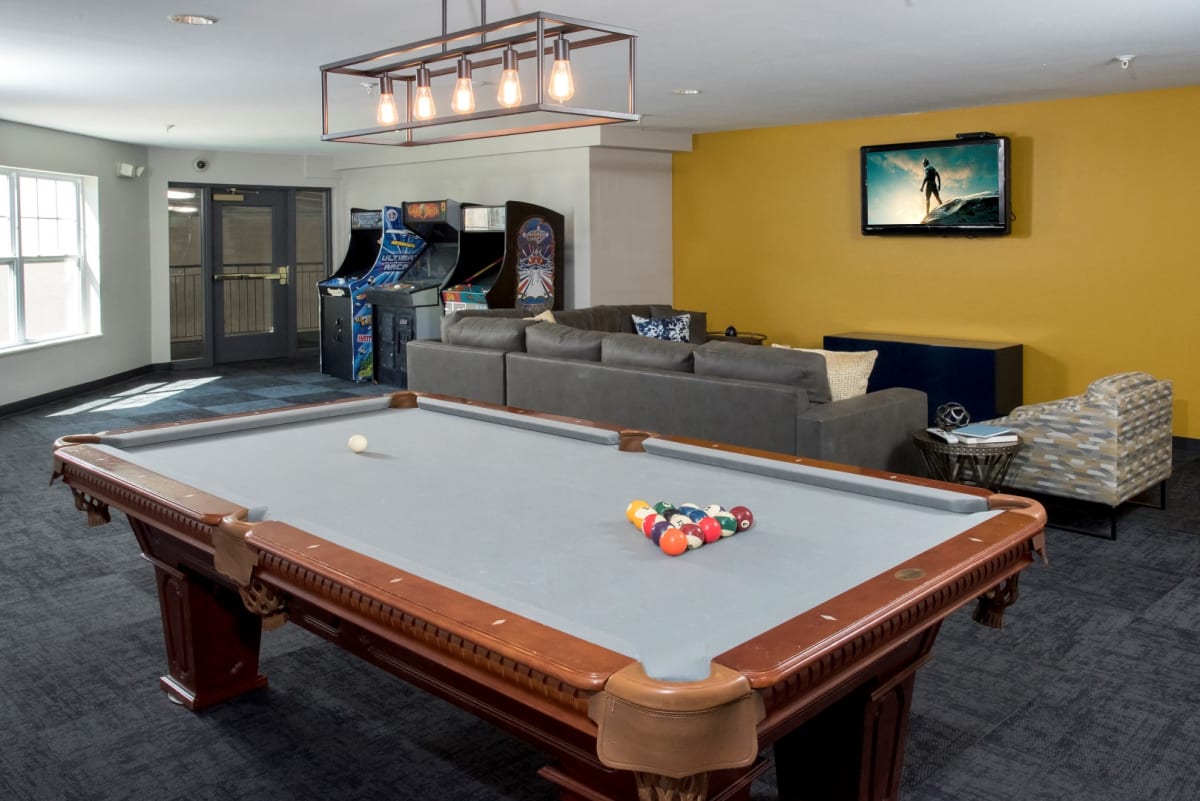 Entertainment room with a billiards table, lounge seating, and arcade games