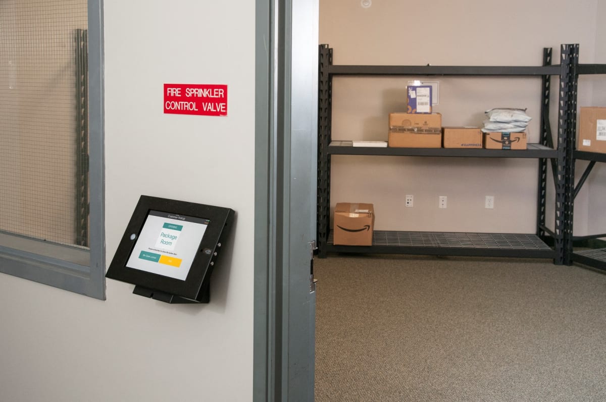Package room with a pickup kiosk and shelving