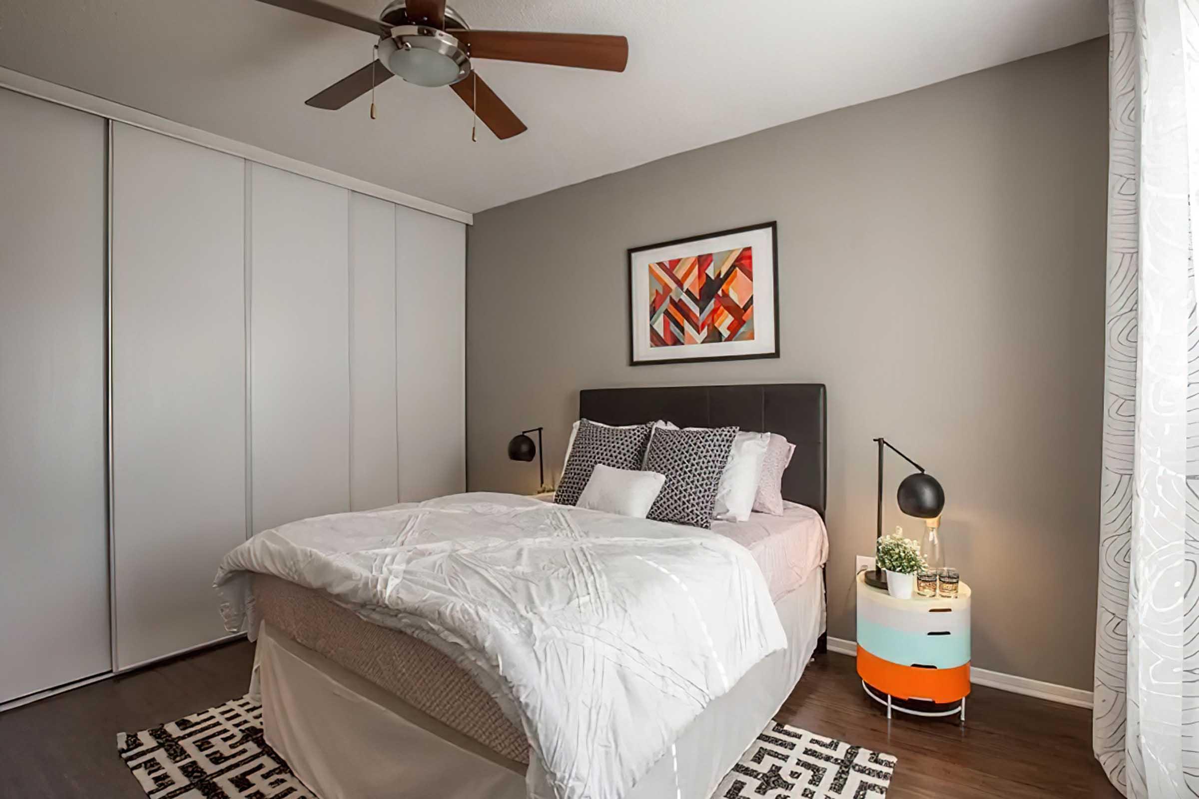 Furnished District at Midtown model bedroom with wood-look flooring.