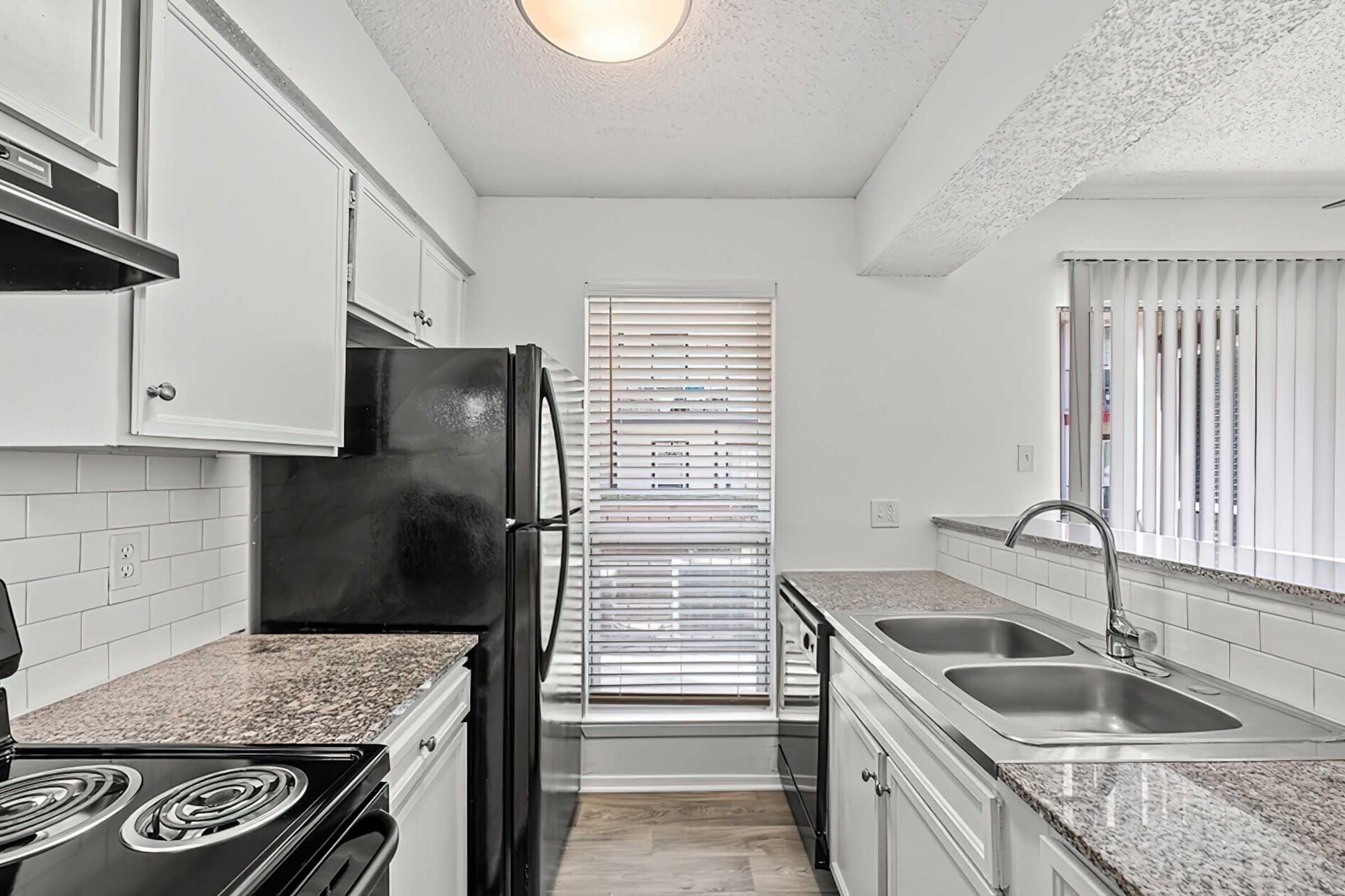 District at Midtown kitchen with white cabinets and granite counters.
