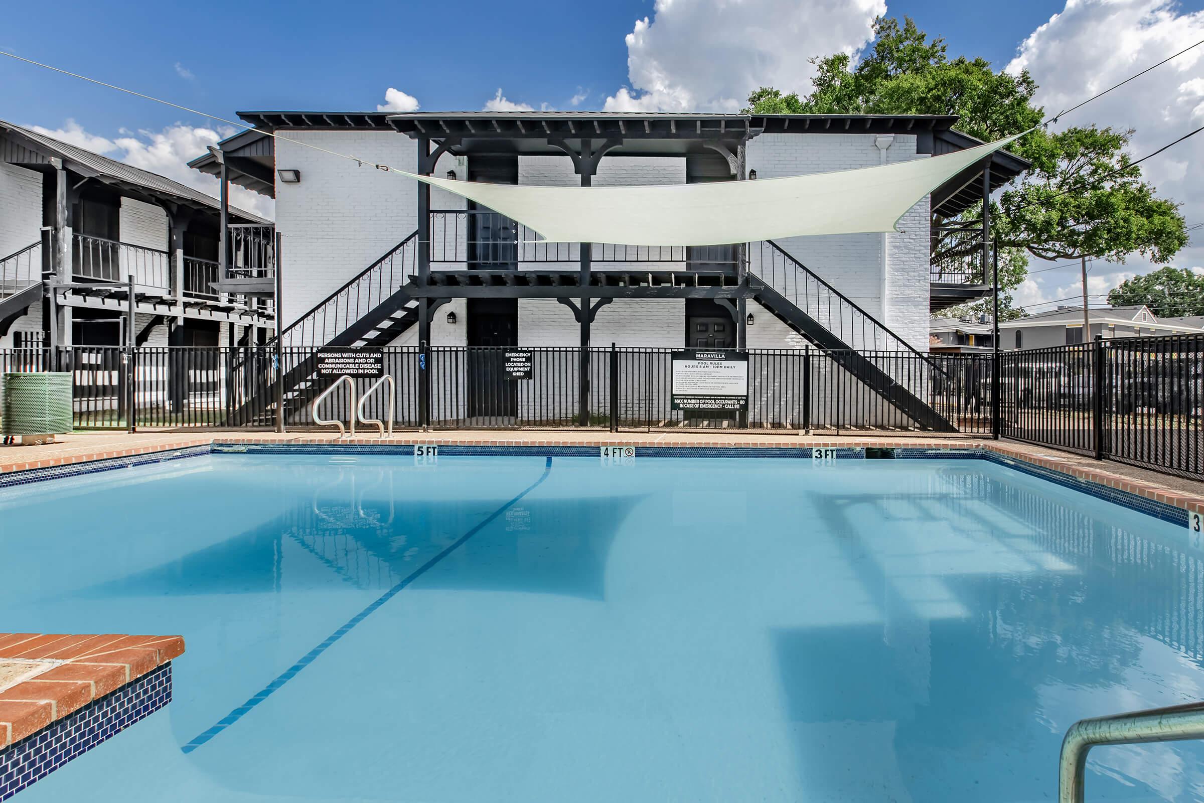 Maravilla swimming pool with a shade sail above the deck.