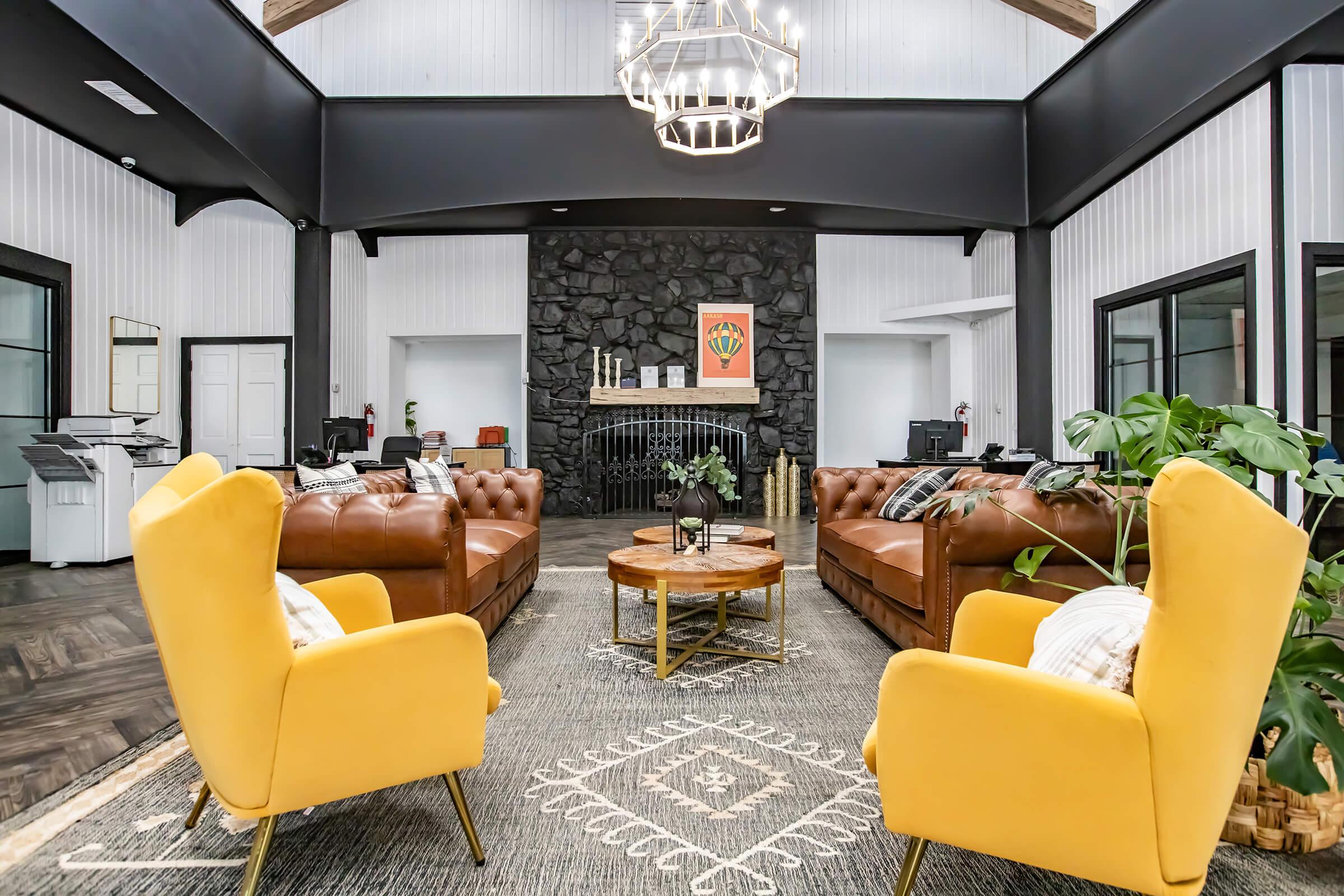 Maravilla clubhouse seating with fireplace and yellow armchairs.
