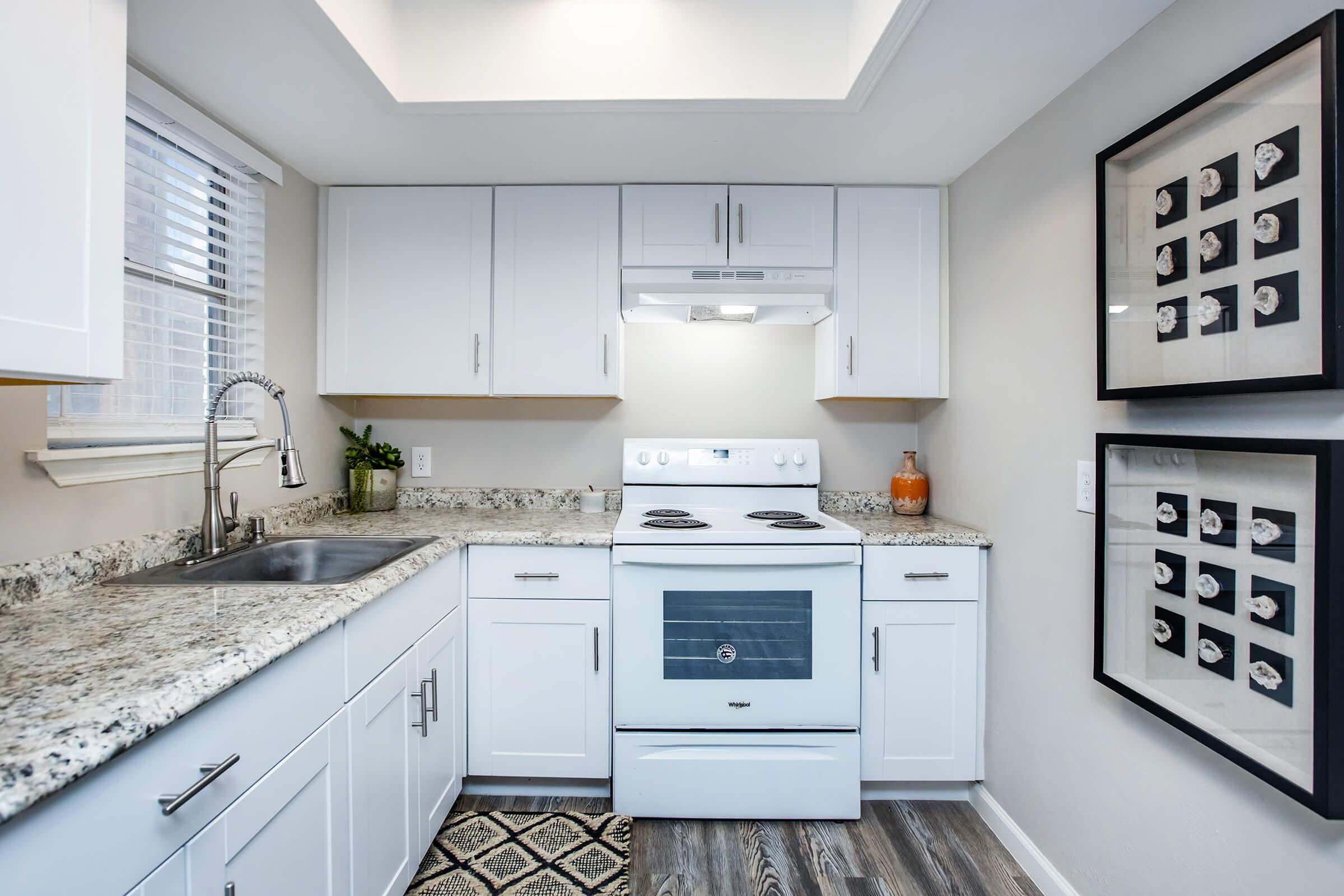 Maravilla model kitchen with electric range and white cabinetry.
