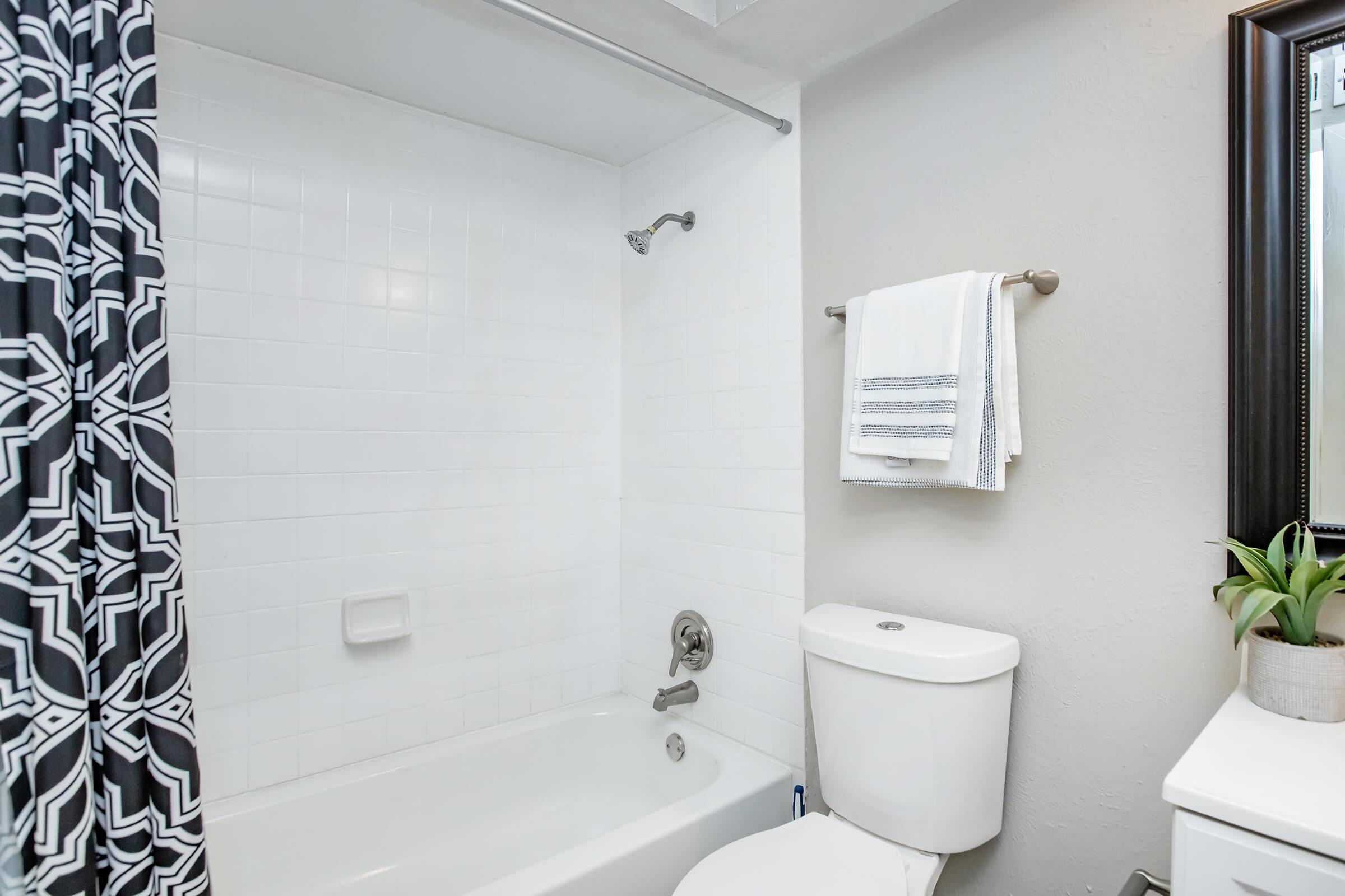 Maravilla model bathroom with bathtub and shower curtain.
