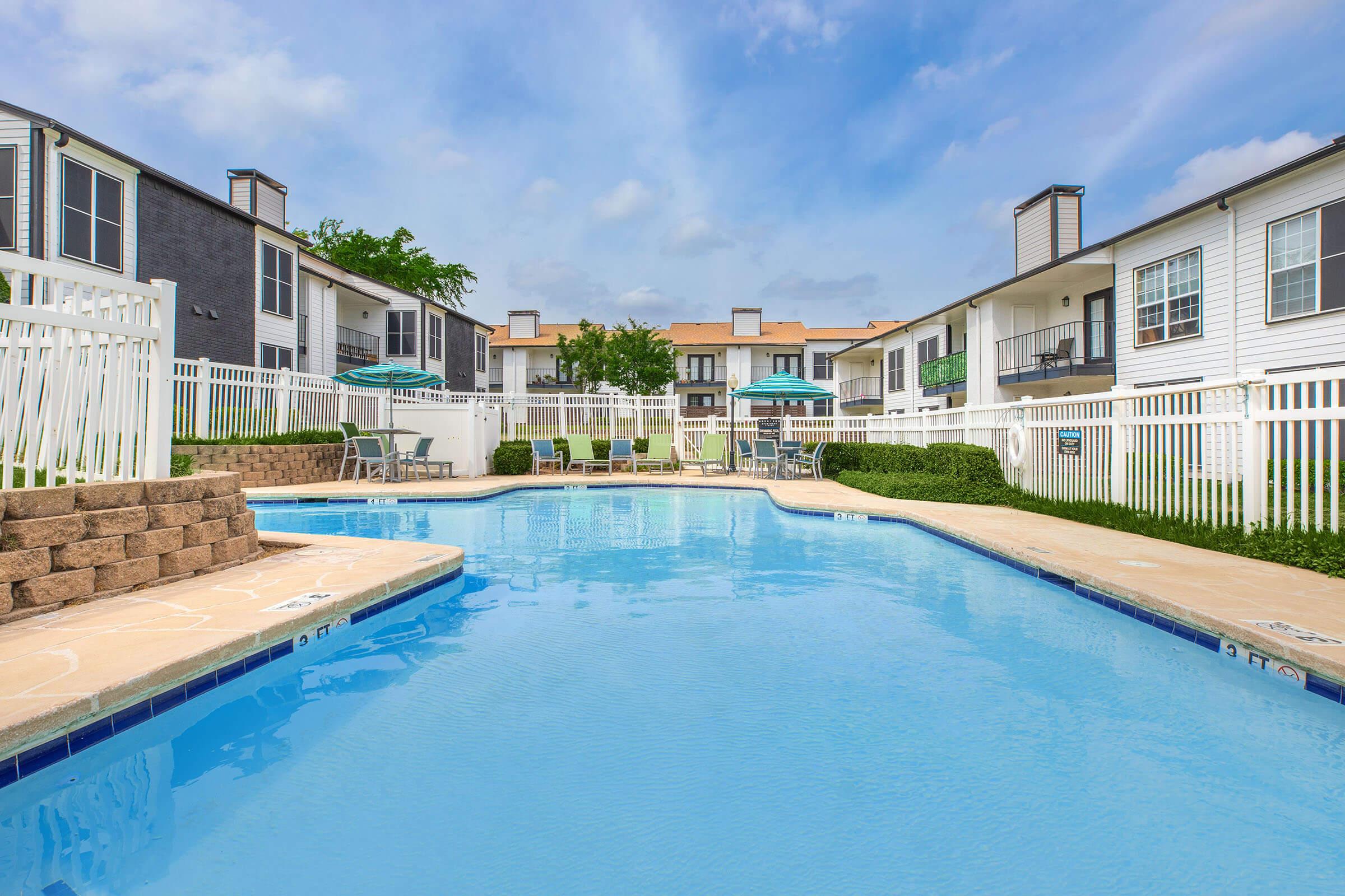 Swimming pool and sundeck enclosed by apartment buildings