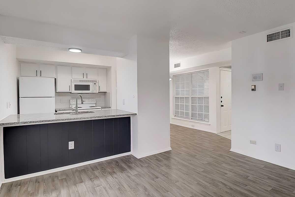 Open apartment living area adjoining a kitchen with a breakfast counter