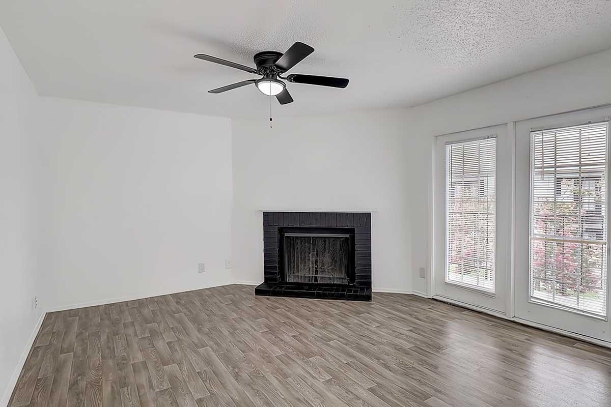 Apartment living room with a fireplace, wood-look flooring, and ceiling fan