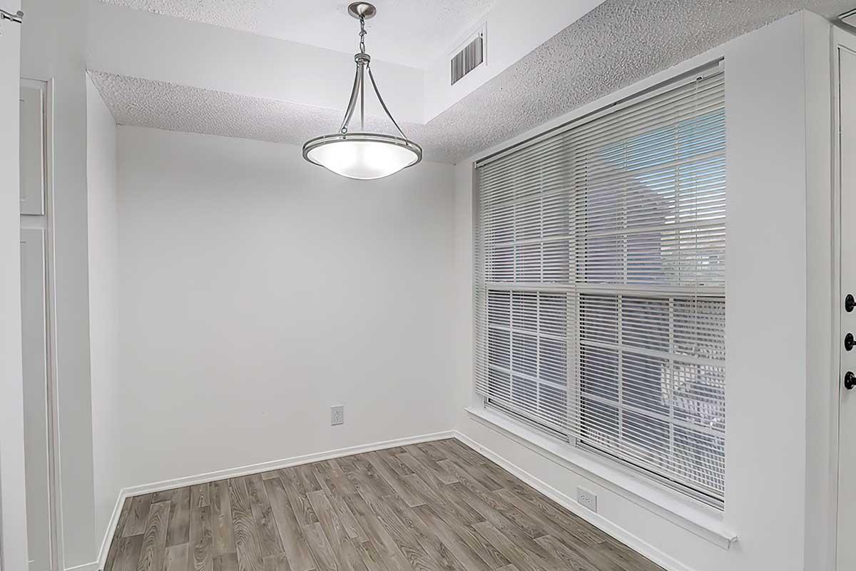 Apartment dining area with a hanging light and large window