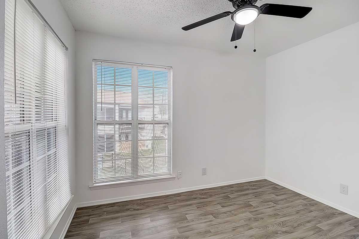 Apartment bedroom with wood-look flooring and a ceiling fan