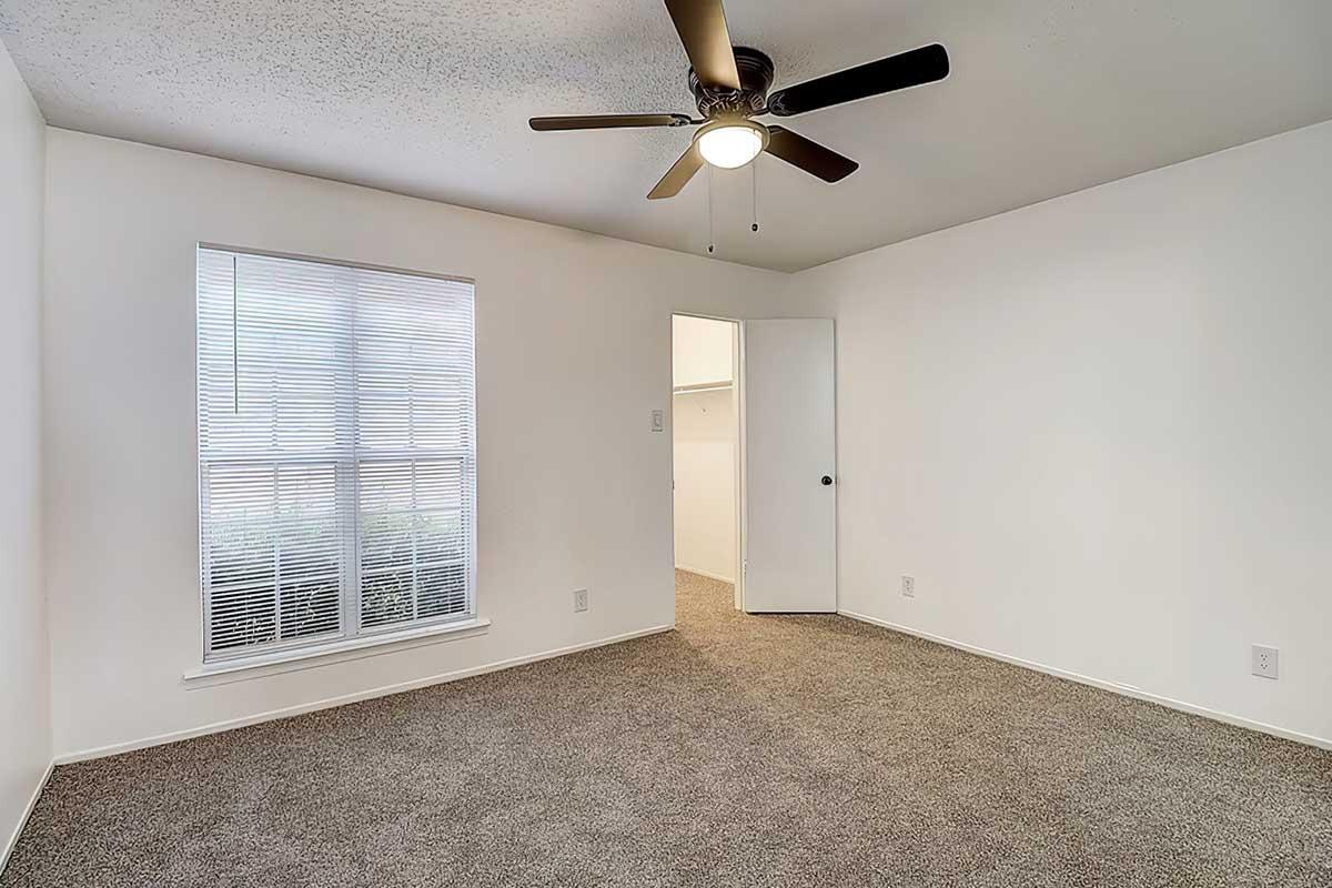 Apartment bedroom with carpet and a ceiling fan
