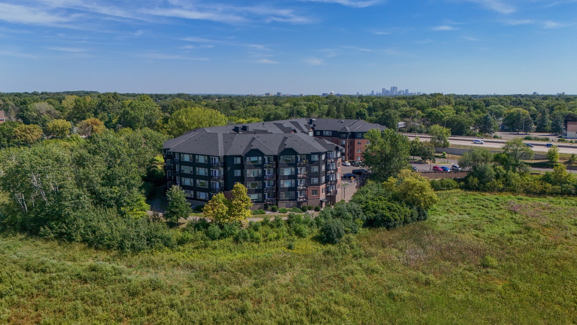 Aerial view of Waterstone Place apartment buildings surrounded by wetland vegetation and trees.