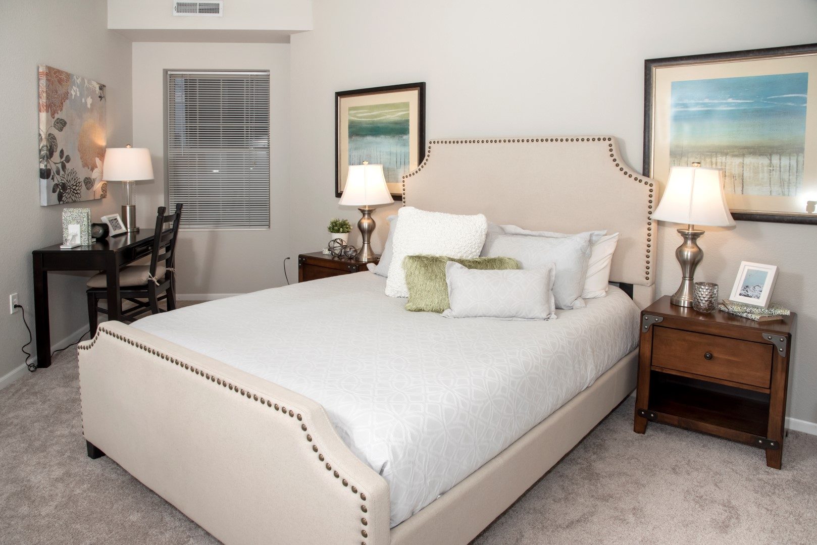 Furnished apartment bedroom with a bed, nightstands, and a desk at Waterstone Place.