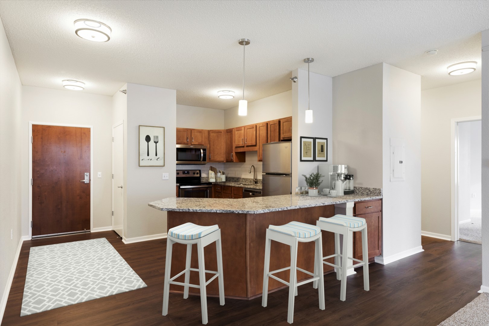 Apartment kitchen with a breakfast bar, cherrywood cabinets, and stainless steel appliances at Waterstone Place.