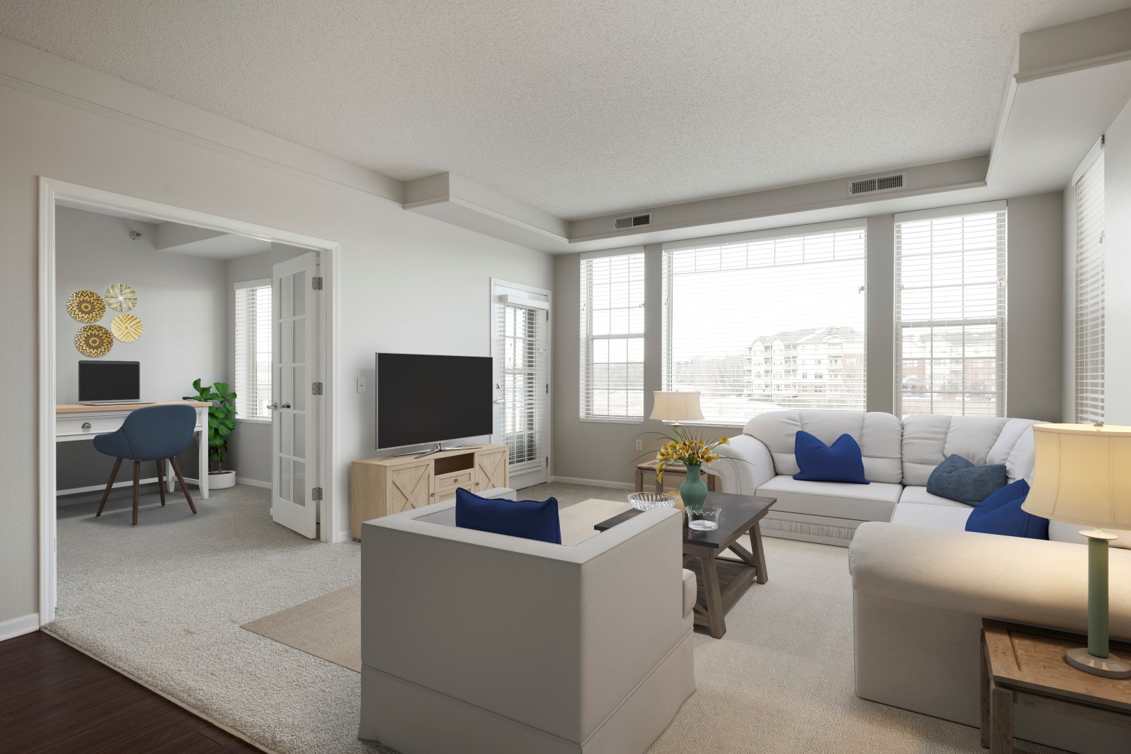 Furnished apartment living room with large windows and an adjacent den at Waterstone Place.