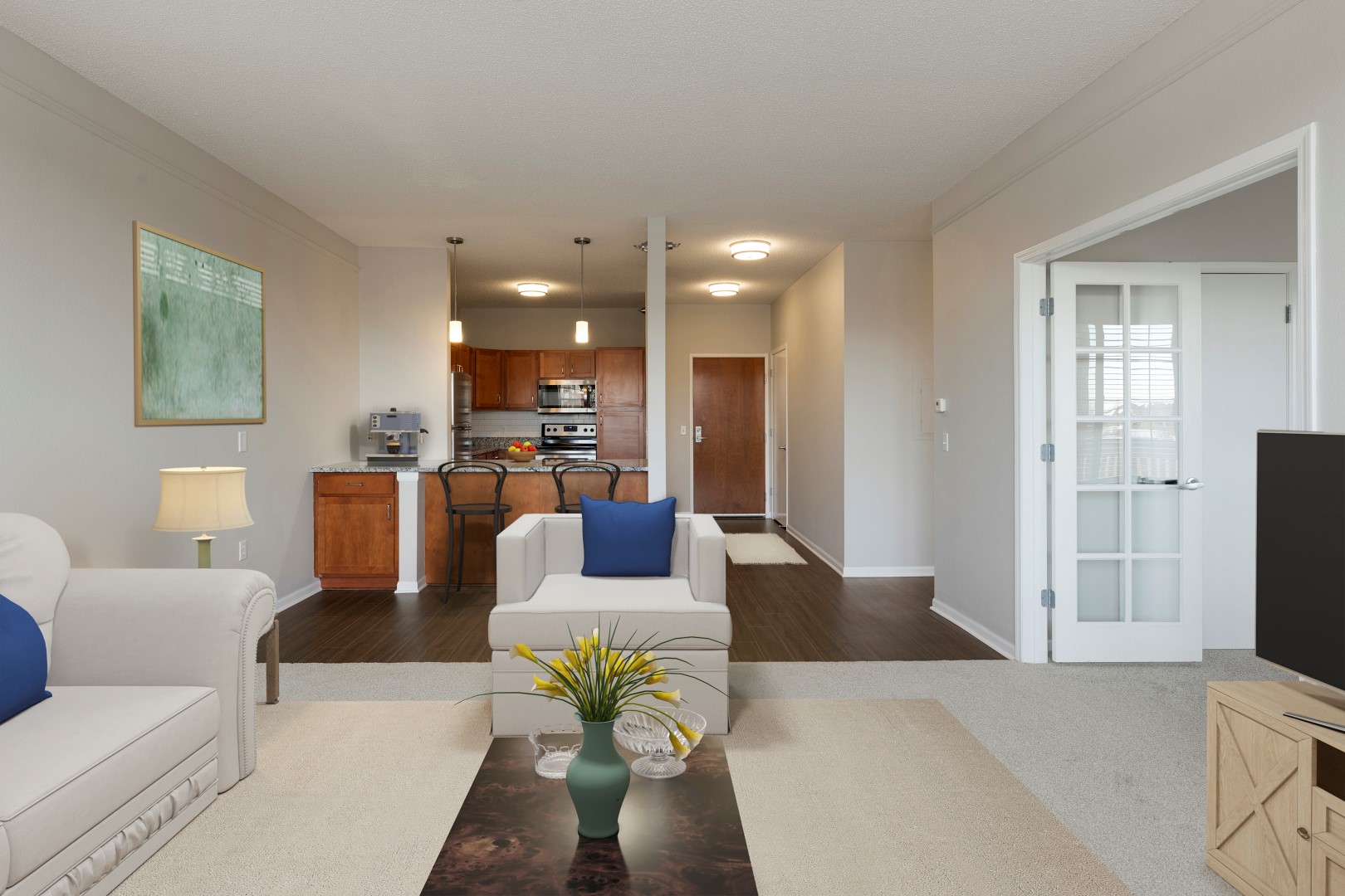 Open apartment living and dining area looking toward the kitchen and adjacent den at Waterstone Place.