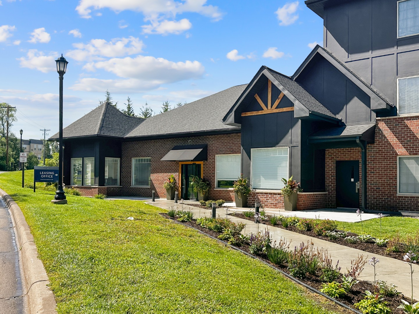 Waterstone Place clubhouse exterior beside a landscaped lawn and sidewalk.