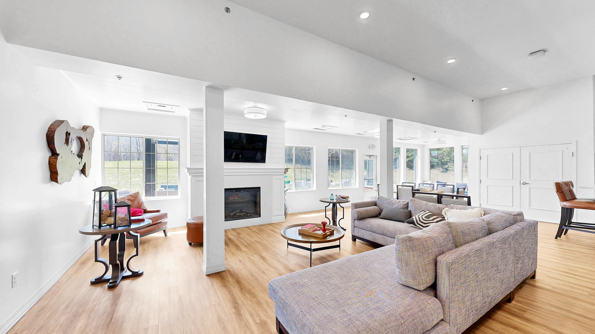 Waterstone Place clubhouse lounge with sofas, a fireplace, and large windows.
