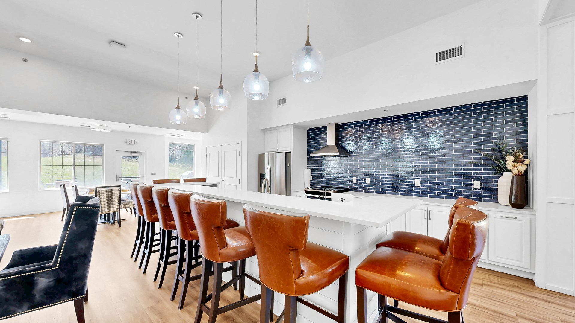 Waterstone Place demonstration kitchen with island seating and a tile backsplash.