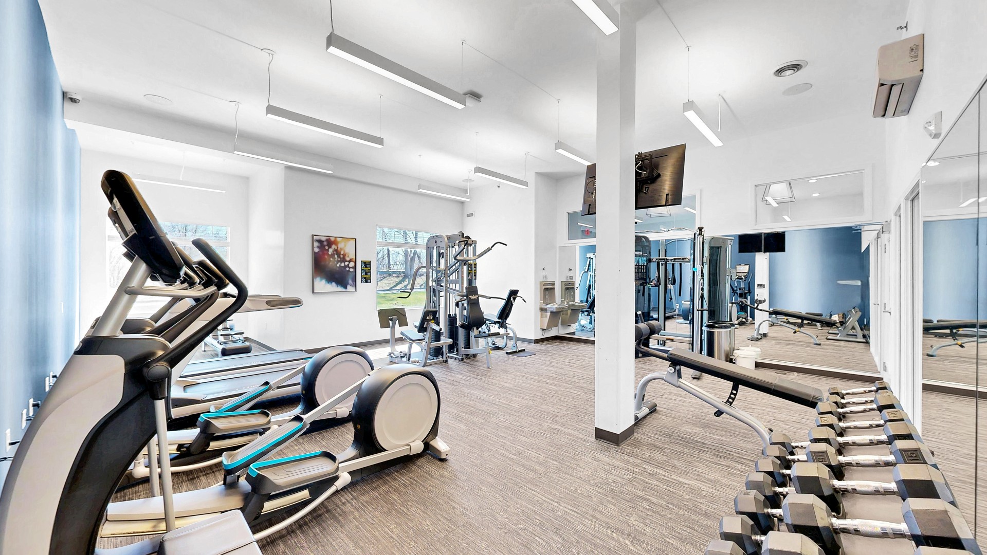 Waterstone Place fitness center with cardio equipment, dumbbells, and strength equipment.