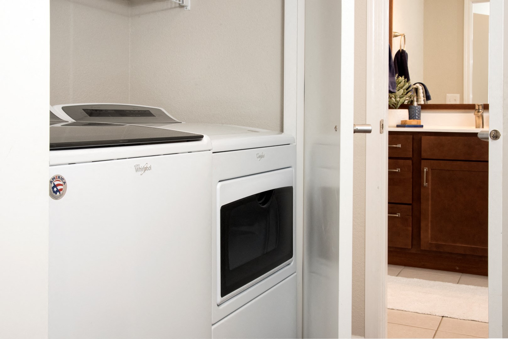 Full-size in-home washer and dryer beside an apartment bathroom at Waterstone Place.