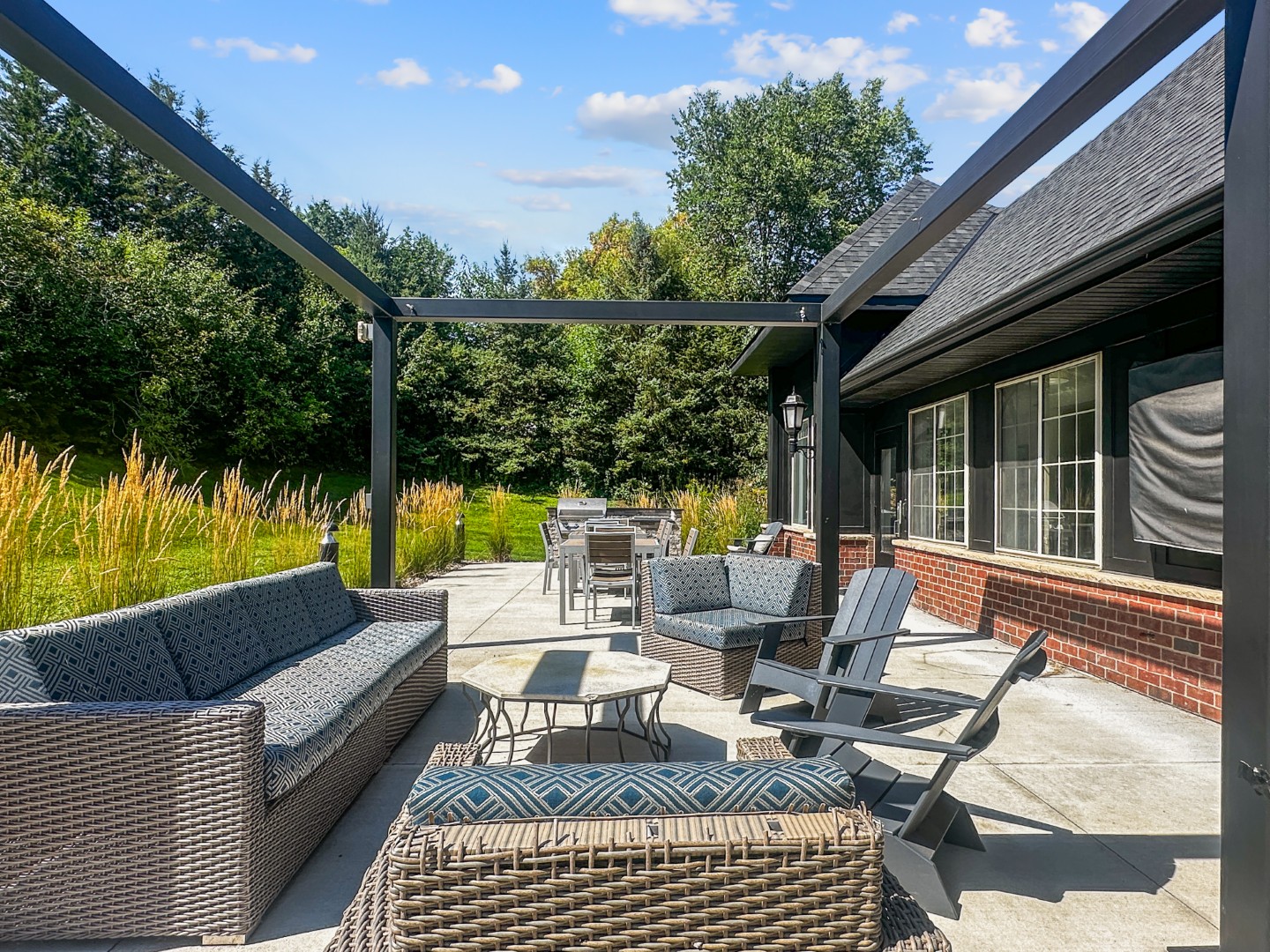Waterstone Place outdoor patio with lounge seating, a pergola, and a dining table.